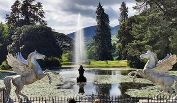 Fountain with sculptures of mythical horses in a garden setting.