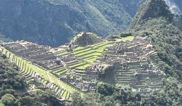 Aerial view of Machu Picchu ruins surrounded by mountains.