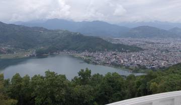 Overview of a city and lake surrounded by mountains.