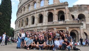 Group of people posing in front of the Colosseum in Rome.
