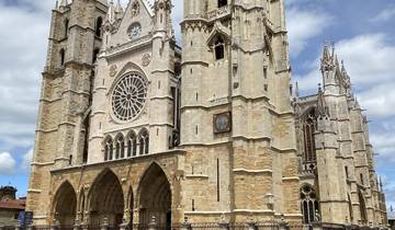 Cathedral facade with large sign and clear blue sky.