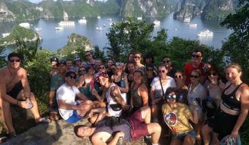 Large group posing with a scenic bay in background.