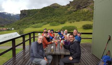 Group of people dining outdoors with a mountainous background.