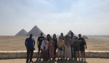 Group of people with the Pyramids of Giza in the background.