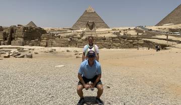 Tourists posing with the pyramids and the Sphinx in Giza.