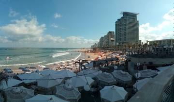 Beachfront city skyline with people on the beach.