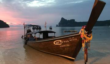 Longtail boat on a beach at sunset.