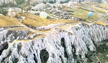 Aerial view of rocky valleys and hot air balloons.