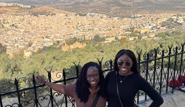 Two women in front of a cityscape view.
