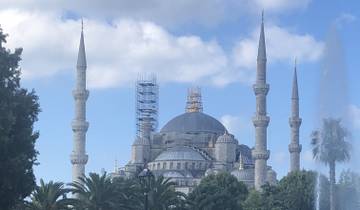 Historic mosque with multiple minarets and scaffolding.