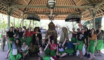Group of people in traditional attire posing under a gazebo.