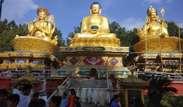 Golden Buddha statues with people in the foreground.