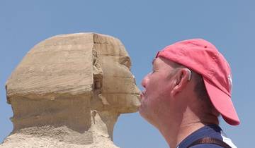Person playfully posing to kiss the Sphinx.