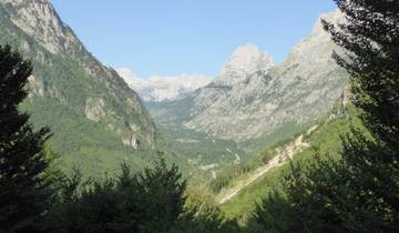 A valley with distant mountain peaks and blue skies.