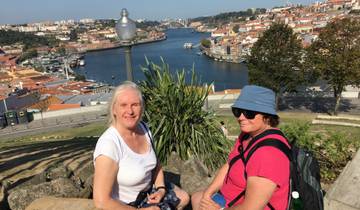 Two women sitting with an overlook of a city and river.