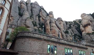 Rocky mountain landscape with a stone structure in front.
