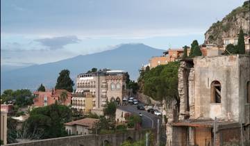 Scenic view of a town with Mount Etna in the background.