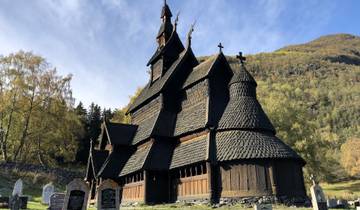 Traditional Norwegian stave church set against a hillside.