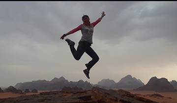 Person jumping with a scenic mountainous desert background.
