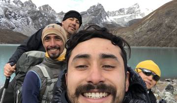 Group of hikers posing in front of a mountain lake.