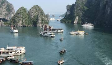Halong Bay with cruise ships moored in calm water.