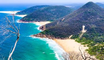 Coastal landscape with turquoise waters and mountain ranges.