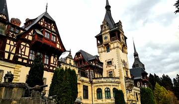 Peles Castle with its ornate architecture and surrounding trees.
