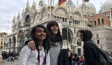 Two people posing in front of a historic basilica.