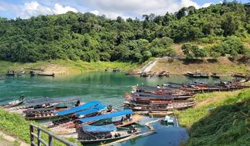 Boats docked in a lake with surrounding greenery.