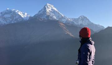 Person observing snowy mountain peaks.