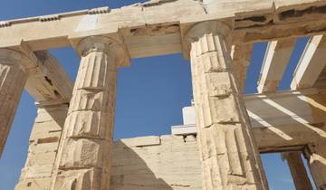 Ancient Greek columns of a temple against a blue sky.