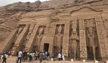 Tourists exploring an Egyptian temple's exterior.