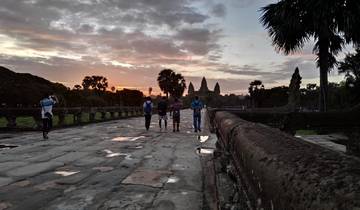 Group of people walking towards temples at sunset.
