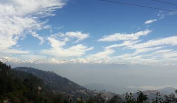 Mountain range under a blue sky with clouds.