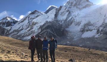 Group of people standing with snow-capped mountains in the background.