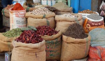 Market stall displaying varieties of spices in sacks.