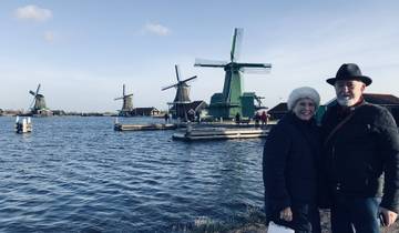 Couple posing with windmills and a waterway.