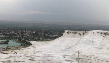 Natural travertine terraces overlooking a city.
