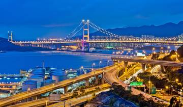 Cityscape at night with illuminated bridge and highways.