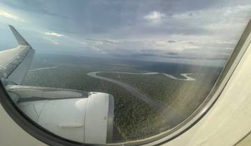Aerial view from a plane window showing a winding river.