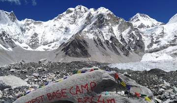 Everest Base Camp marker with snowy mountains in the background.