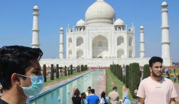 Visitors near the Taj Mahal with a reflecting pool.