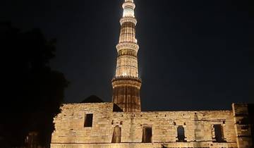 The Qutub Minar tower illuminated at night in New Delhi.