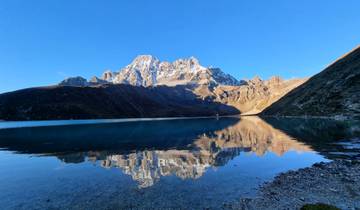 Snow-capped mountain reflected in a lake.
