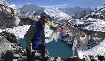 Person with prayer flags and snowy mountains.