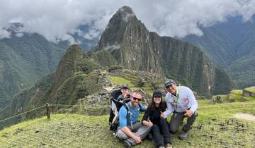 Family posing at Machu Picchu with the mountain in the background.