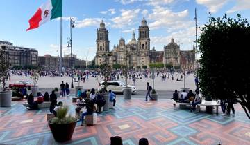 Wide shot of a public square with people and a large cathedral.