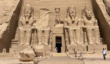 Front view of Abu Simbel with huge statues and tourists.