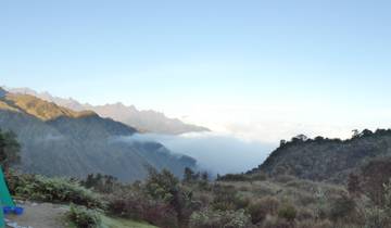 A panoramic view of mountain ranges with clouds below.