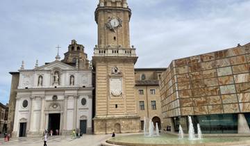 Historical building with a clock tower and fountains.